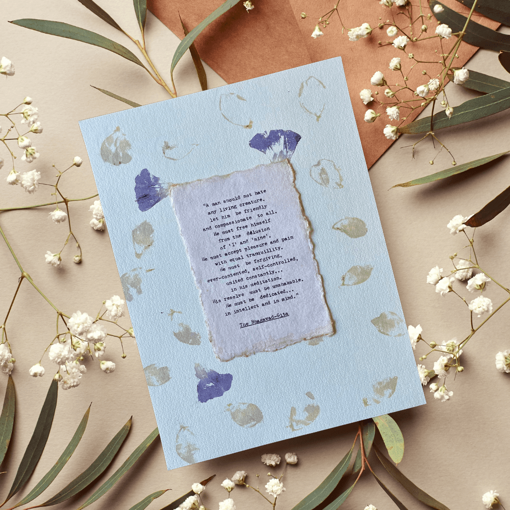 Art made using pigment from real plants depicting a floral backdrop with a typewritten quote from The Bhagavad-Gita on handmade cotton paper on top.