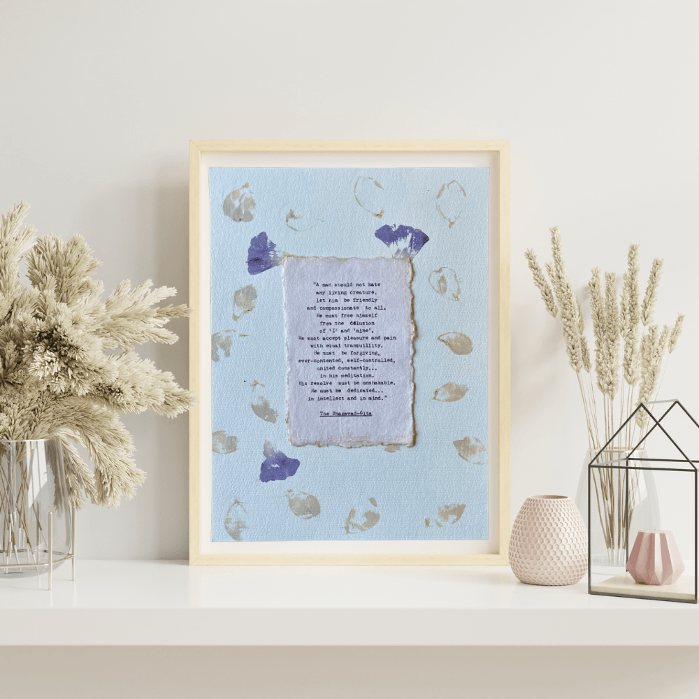 Art made using pigment from real plants depicting a floral backdrop with a typewritten quote from The Bhagavad-Gita on handmade cotton paper on top.
