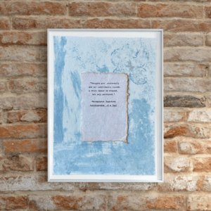 Art made using pigment from real plants depicting a blue backdrop with a typewritten quote by Paramahansa Yogananda on handmade cotton paper on top.