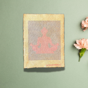 Handmade typewriter art on handmade, recycled, deckled-edged cotton paper. The repeated word “yoga” is hand typed in black on a typewriter. Red letters form a visual of a seated meditator among the black text. The piece is displayed on a sage green background with light pink carnations arranged to the right. At the bottom of the art, the website “www.PlantsAreMyType.com” appears in red.