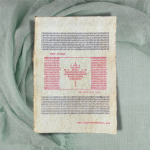 The word, "CANADA" is typed repeatedly on handmade, recycled cotton paper to form an image of the Canadian flag using red and black ink along with negative space. The words, “dear Canada, we hate him too.” frame the flag. The website www.plantsaremytype.com is typed at the bottom right corner of the page. The art sits atop a green linen background.