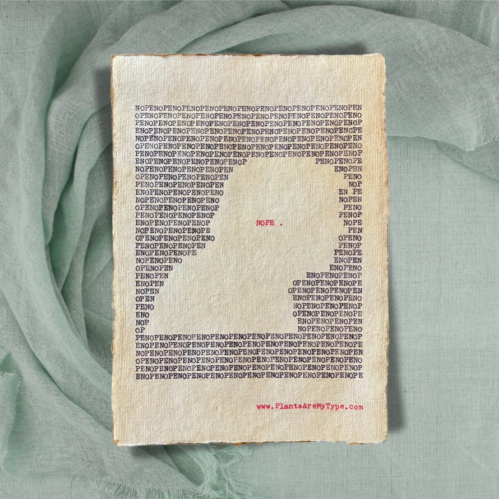The word, "nope" is typed repeatedly on handmade, recycled cotton paper to form an outline of a man’s right-side portrait using black ink and negative space. The word, “nope.” is typed in red inside of the outline. The website www.plantsaremytype.com is typed at the bottom right corner of the page. The art sits atop a green linen background.