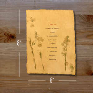 Typewriter art on a wooden background. There are guides showing the paper size, 6"x8". The page is stamped with real flowers and displays a poem about love.