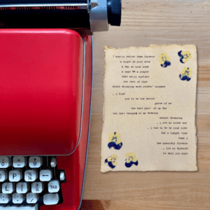 An image of a red typewriter next to typewriter art. The art is stamped with real flowers and displays a poem about love.