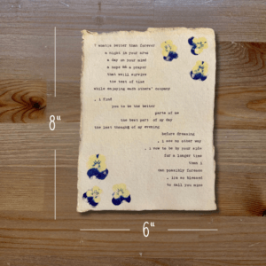 Typewriter art on a wooden background. There are guides showing the paper size, 6"x8". The page is stamped with real flowers and displays a poem about love.