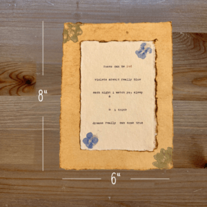 Typewriter art on a wooden background. There are guides showing the paper size, 6"x8". The page is stamped with real flowers and displays a poem about love.