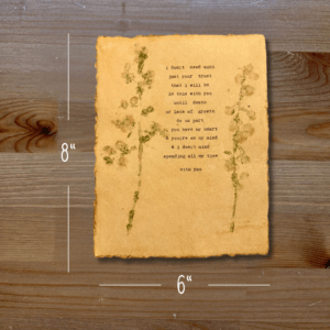 Typewriter art on a wooden background. There are guides showing the paper size, 6"x8". The page is stamped with real flowers and displays a poem about love.